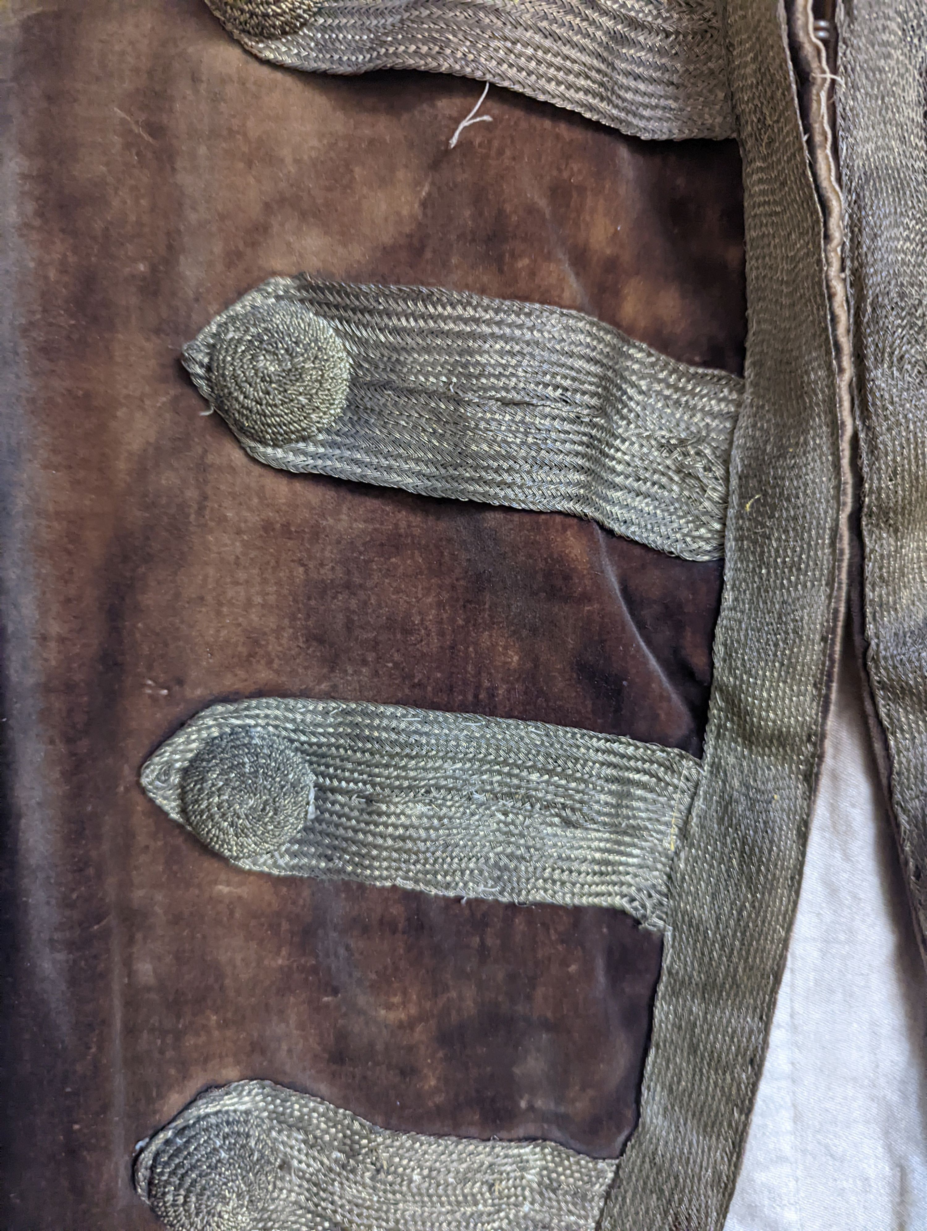 A Georgian gents cream damask waistcoat, a similar waistcoat with beading applied later and a velvet and gold braided tailcoat